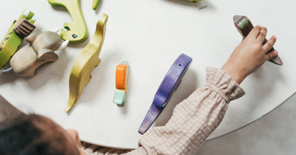 Child playing with colorful wooden toys in a playful indoor setting.