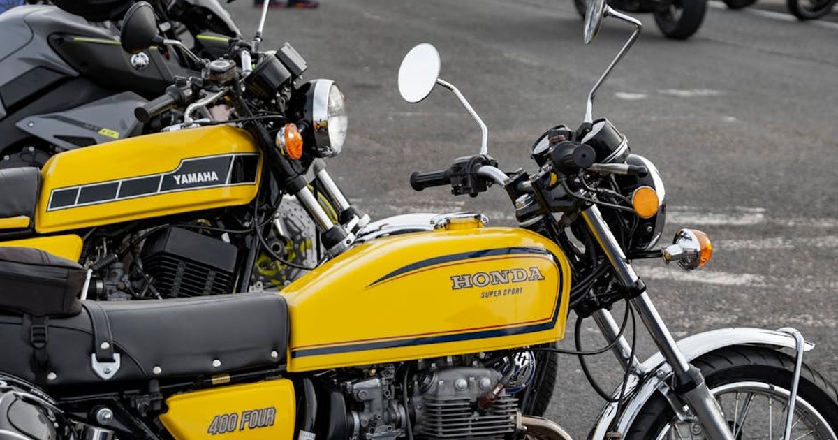Parked vintage Yamaha and Honda motorcycles on a street in Paignton, England. Urban vehicle scene.