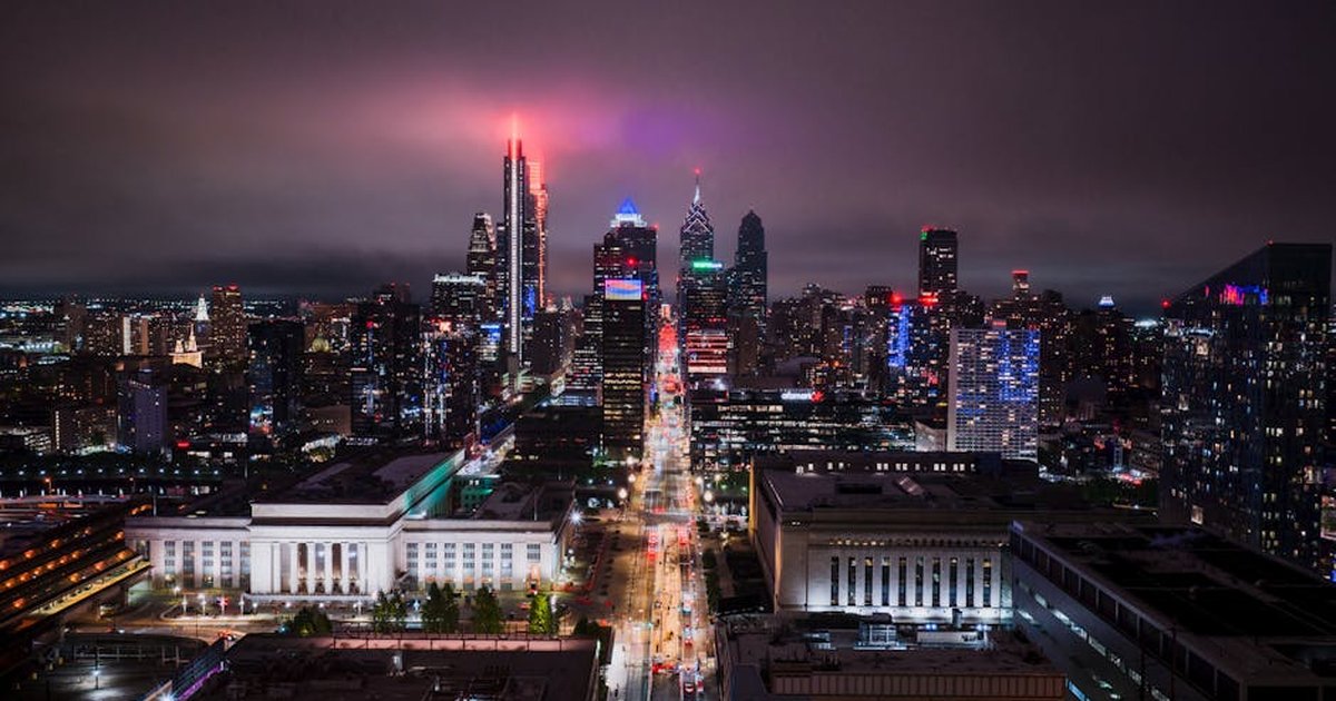 Stunning aerial view of Philadelphia's illuminated skyline at night, showcasing vibrant city lights.