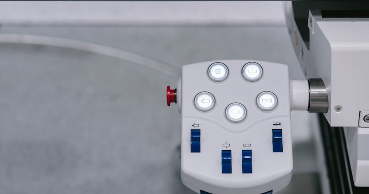 Detailed view of a modern industrial control panel with illuminated buttons and switches.