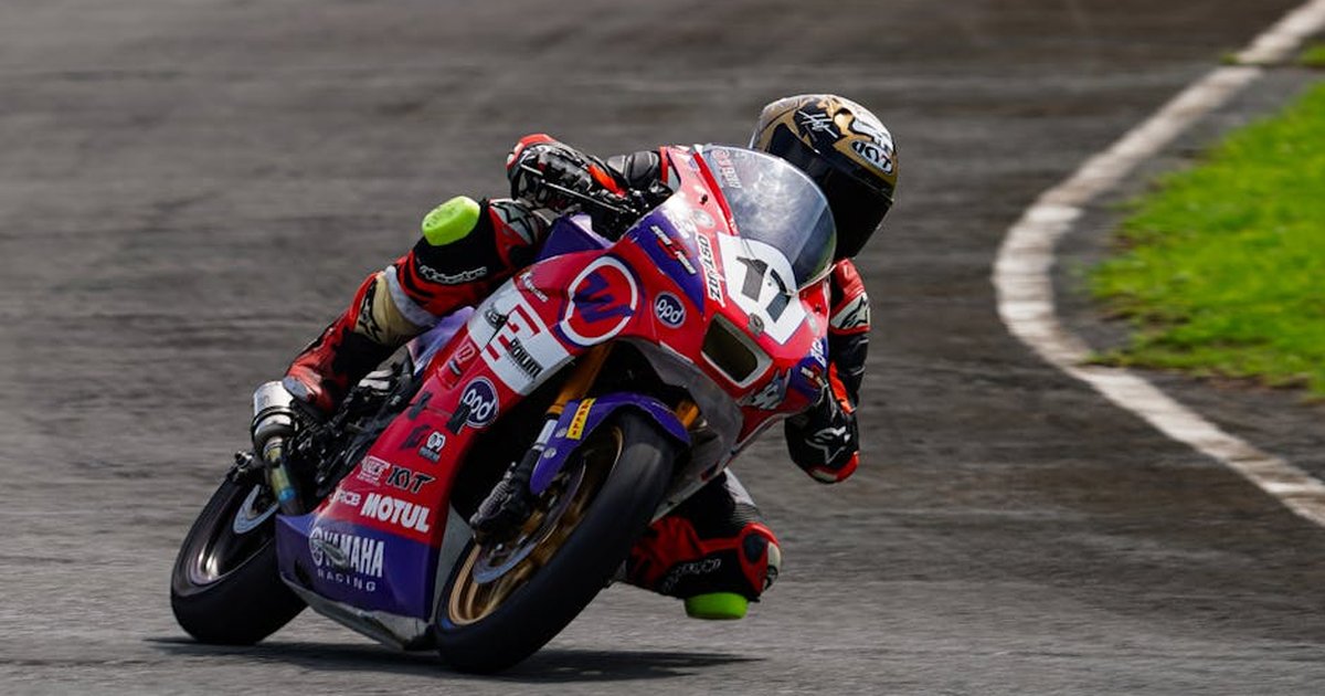 Dynamic shot of a motorcycle racer leaning into a curve on the track, showcasing speed and agility.