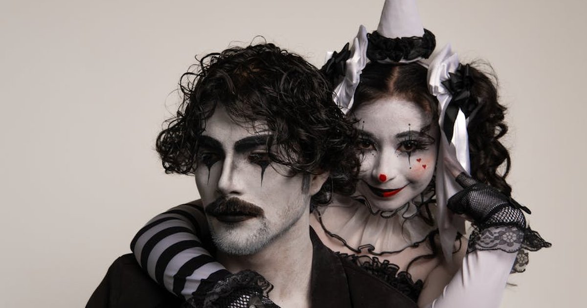 Two adults in harlequin costume and mime makeup, capturing a classic theatrical scene