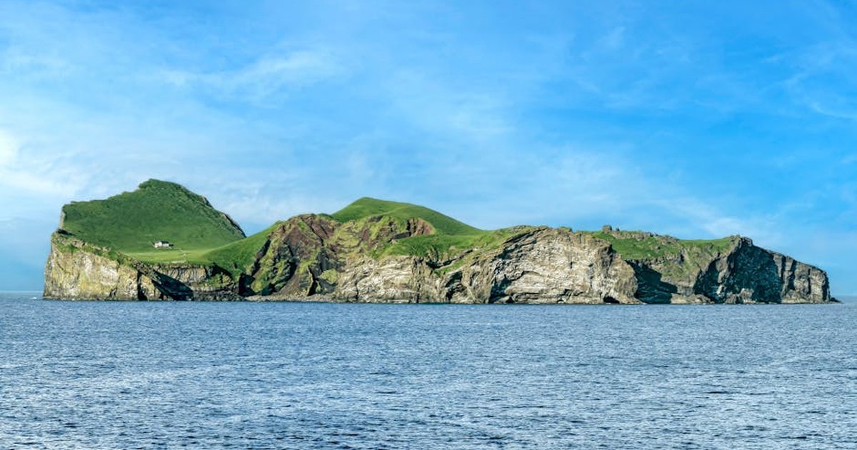 Stunning view of Ellidaey Island in Iceland surrounded by ocean under a clear summer sky.
