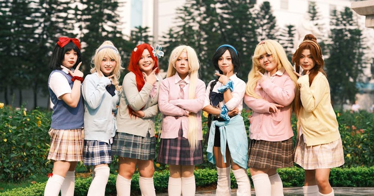 Group of cosplayers posing in vibrant costumes outdoors in Việt Nam with lush greenery.