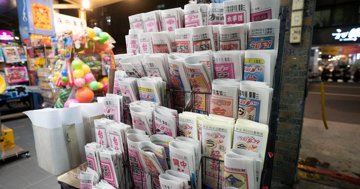 Vibrant newspapers and toys displayed at a bustling night newsstand in the city.