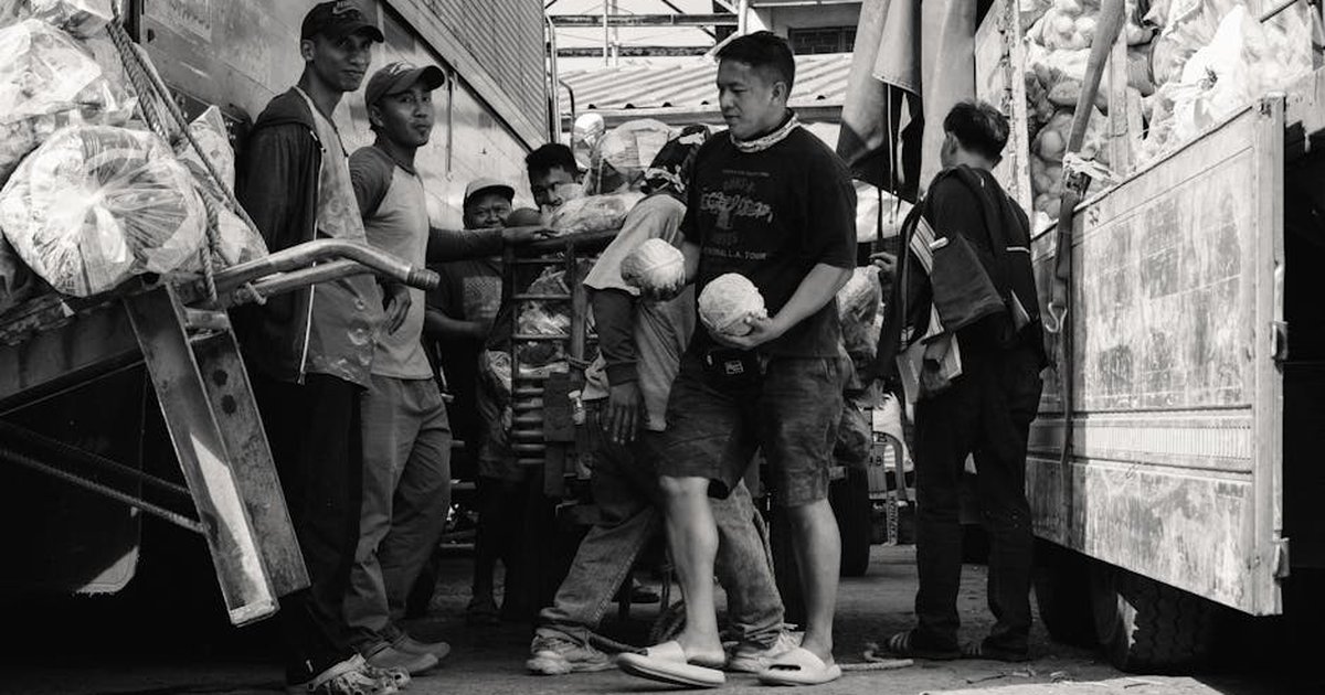 Porters working in a busy market, captured in black and white for a classic look.