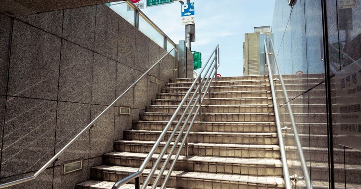Concrete stairs leading out from a Taipei underground setting into bright daylight.