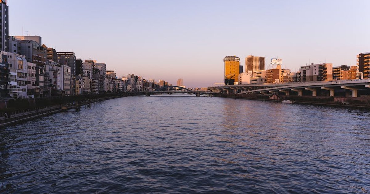 Stunning view of Sumida River in Tokyo, Japan during golden hour with a scenic bridge.