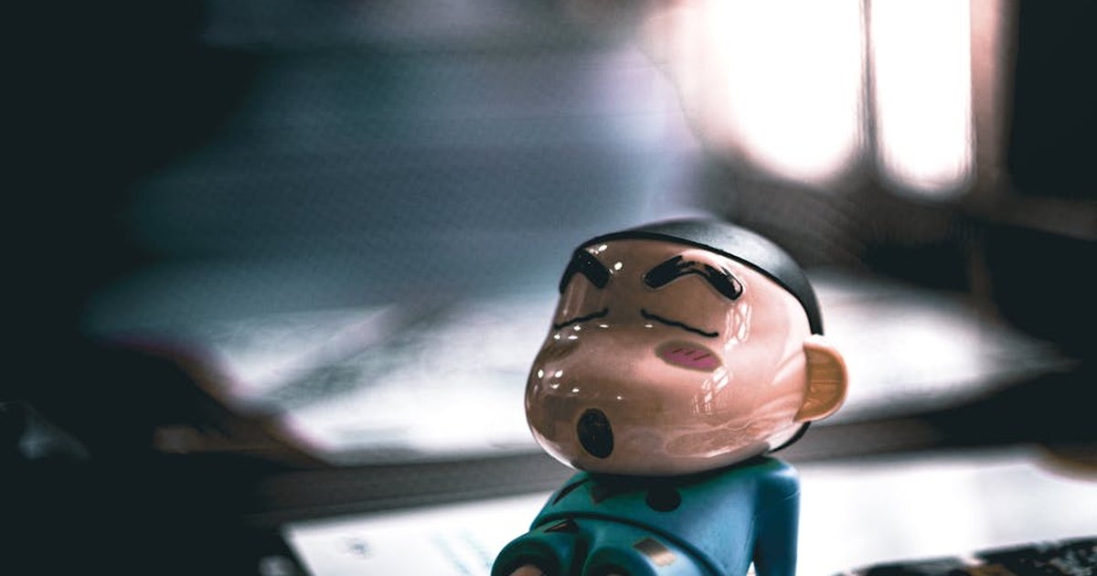 Close-up of a cartoon figurine sleeping on a table with soft lighting.