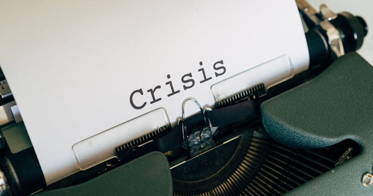 Close-up of a vintage typewriter with the word 'Crisis' typed on paper.