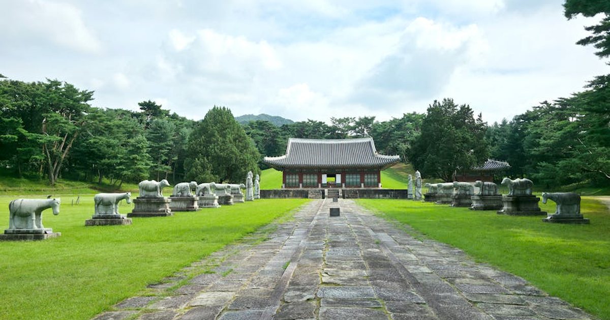 A serene temple surrounded by stone statues and lush greenery in South Korea.