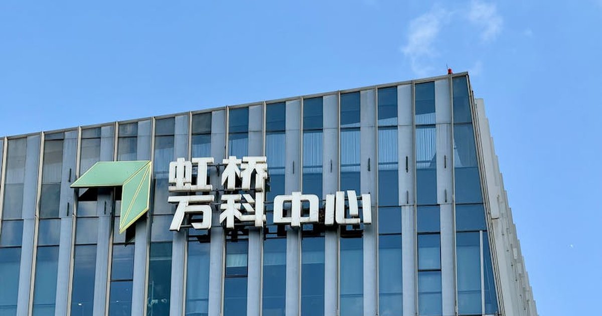 A modern office building with Chinese signage under a clear blue sky.