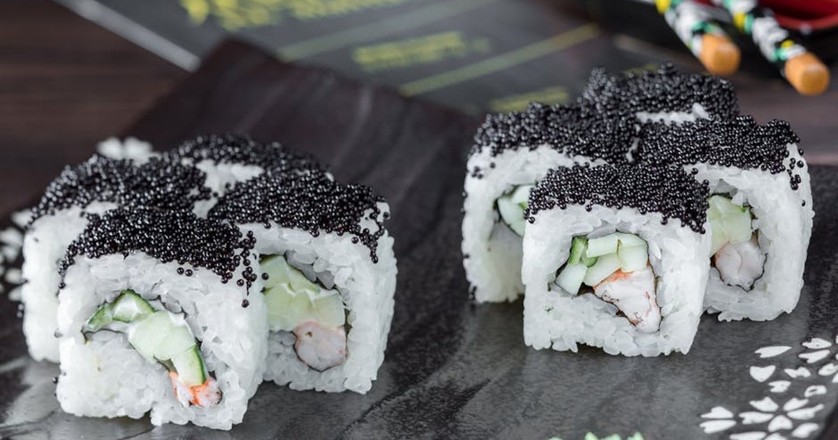 Appetizing sushi rolls topped with black caviar, served stylishly on a dark plate in Istanbul.
