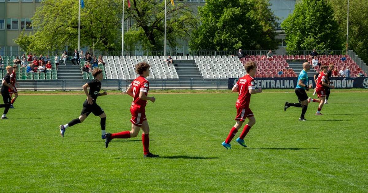 Players competing in a youth soccer match at a stadium in Wrocław, Poland.