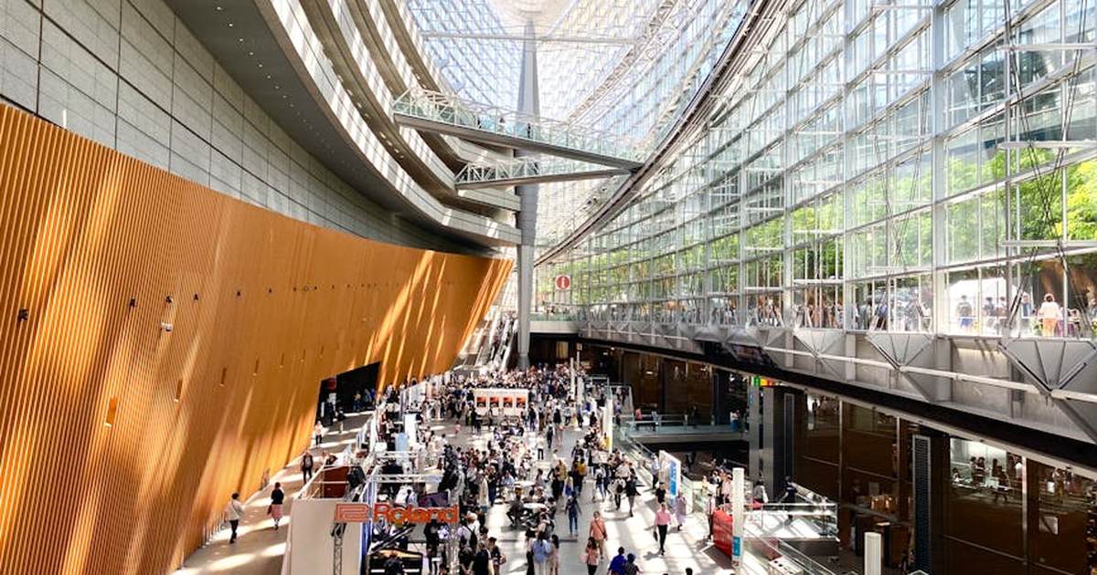A bustling scene inside the modern architecture of Tokyo International Forum in Japan.