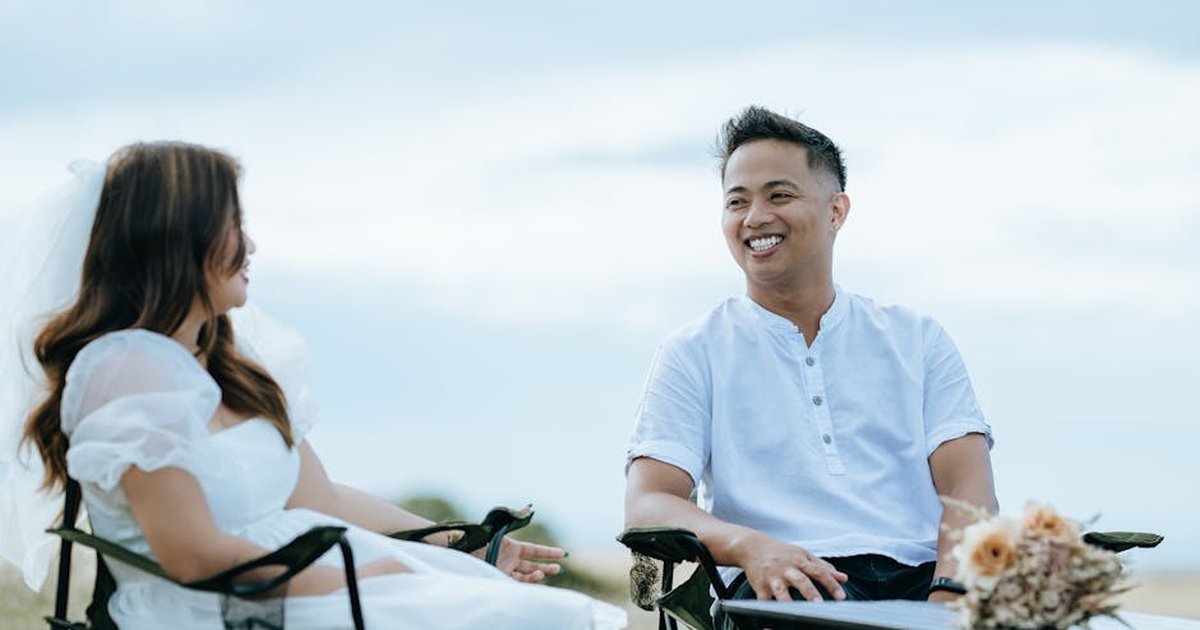 A newlywed couple enjoys an outdoor moment together, beaming with joy.