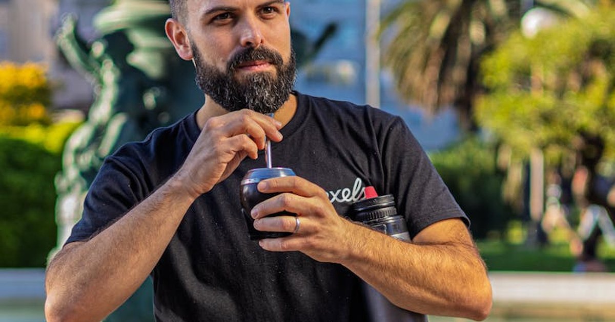 Man enjoying traditional mate drink in Montevideo, Uruguay park. Cultural moment captured outdoors.