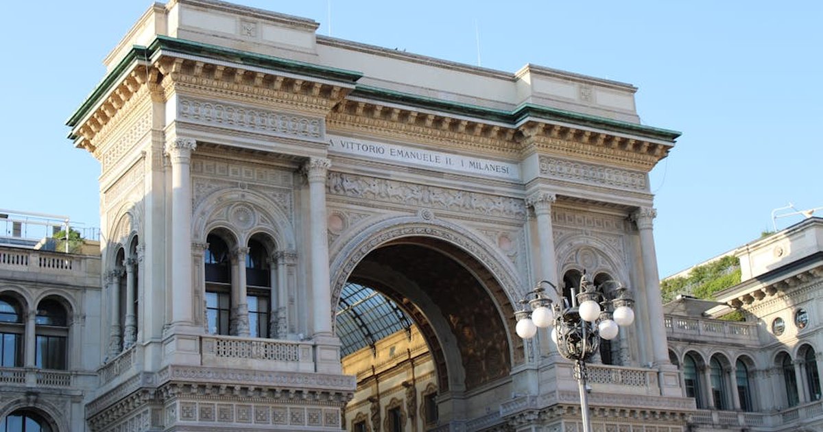 Elegant exterior of Galleria Vittorio Emanuele II in sunny Milan, Italy.