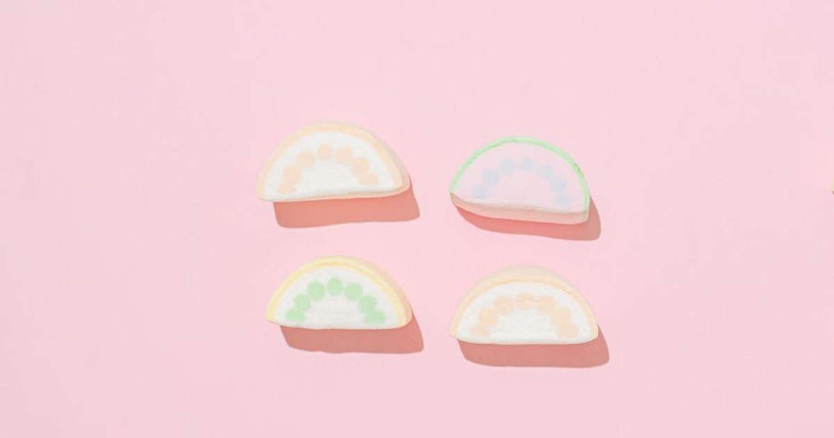 Colorful marshmallow slices on a pastel pink background, creating a sweet and playful vibe.