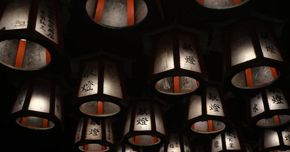 Illuminated traditional Japanese lanterns hanging in the dark, offering a serene ambiance in Shirahama.