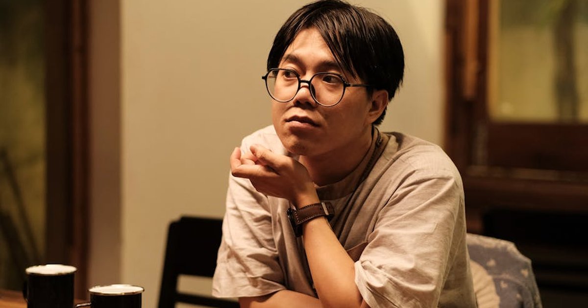 A thoughtful moment captured in a Vietnamese cafe setting, highlighting self-expression.