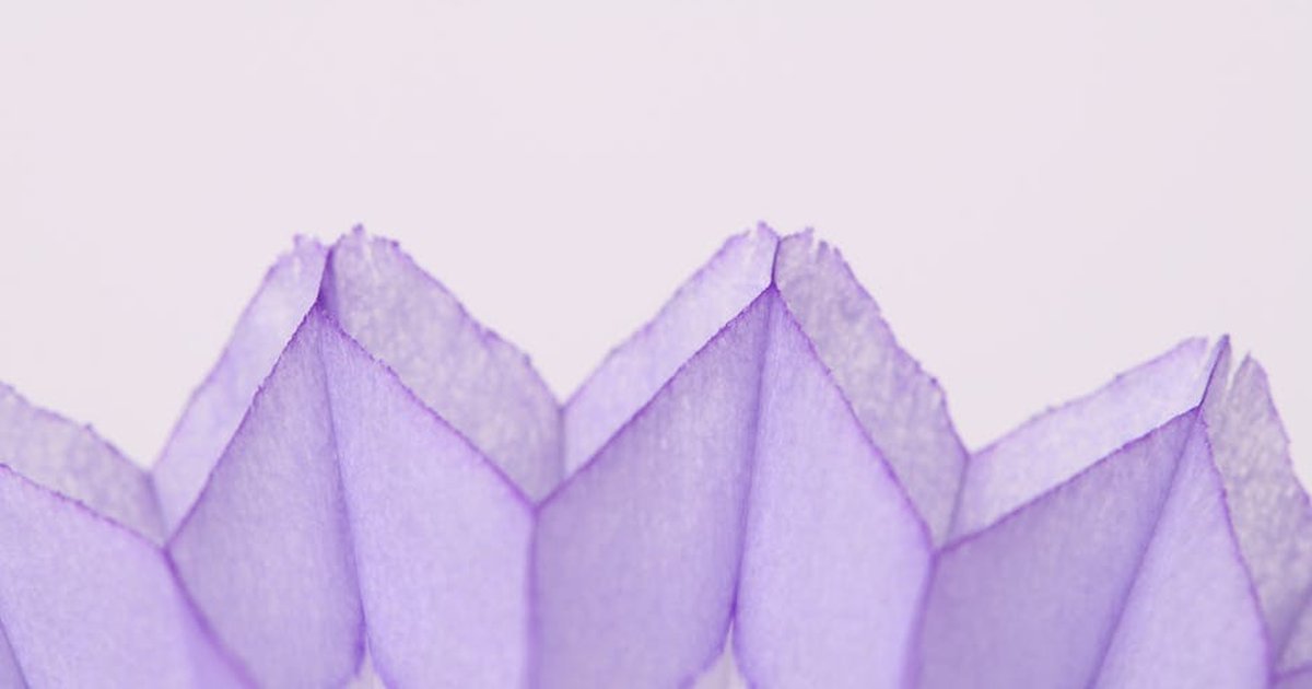 A close-up of abstract violet geometric paper art with a folded pattern.