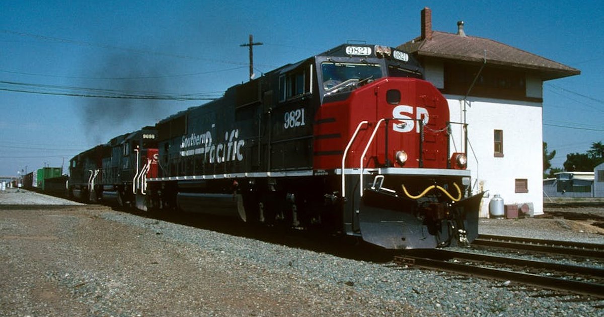 Dynamic view of Southern Pacific freight train passing through Stockton, California on a sunny day.