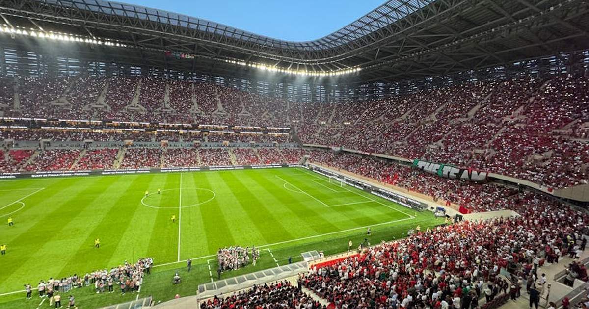 A vibrant football match with cheering fans in a modern stadium.