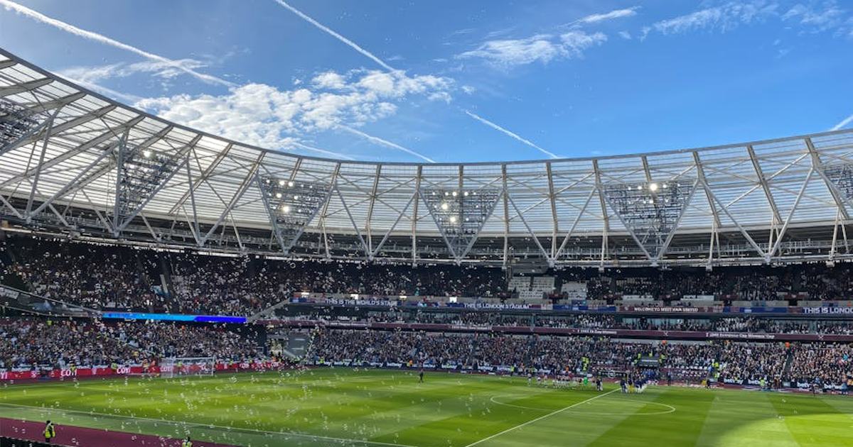 A packed London Stadium hosts a thrilling soccer match, with vibrant atmosphere and engaged crowd.