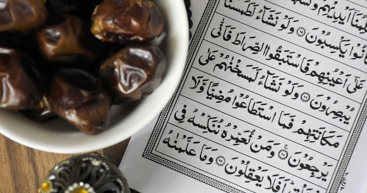 A bowl of dates with Quran, symbolizing Ramadan iftar tradition.