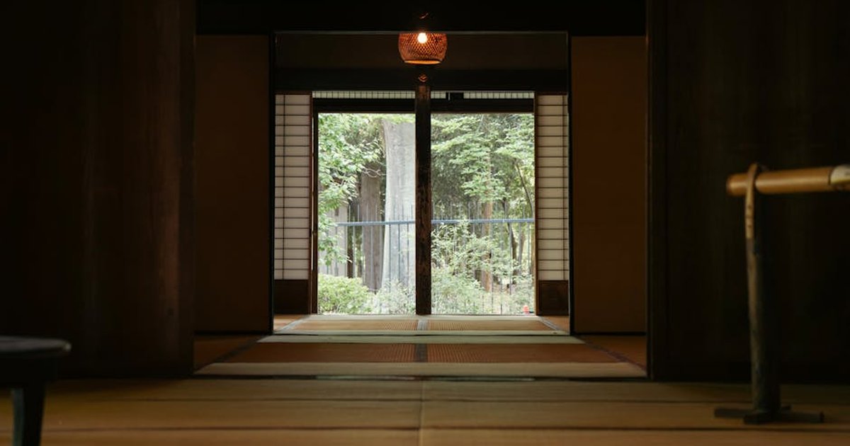 Serene interior of a Japanese room with a garden view through sliding doors.