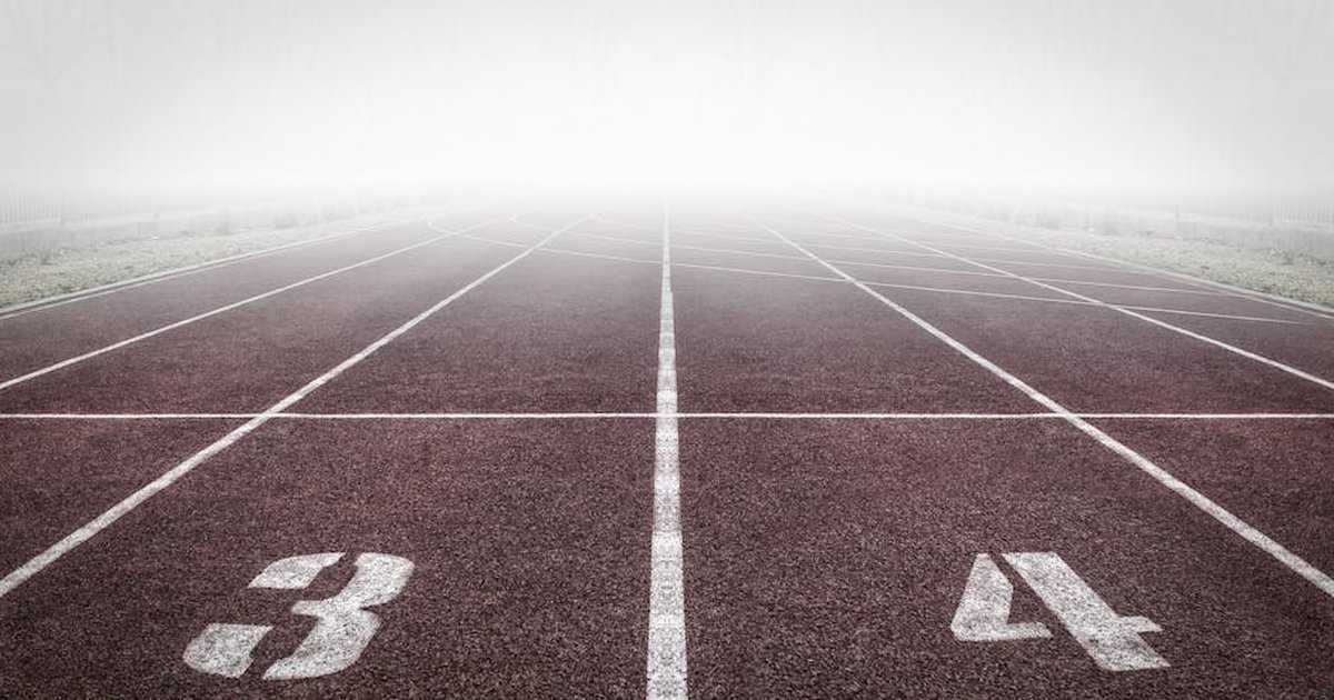 A foggy track field with visible lane numbers and white lines.