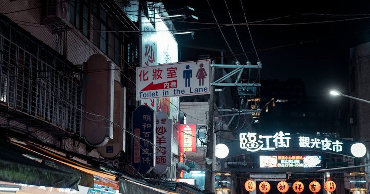 Explore the bustling night market in Taipei, Taiwan, with vibrant street signs and a lively atmosphere.