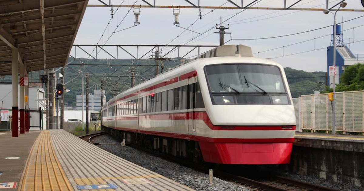 A sleek, red and white train arrives at a railway station in Kiryu City, Japan.