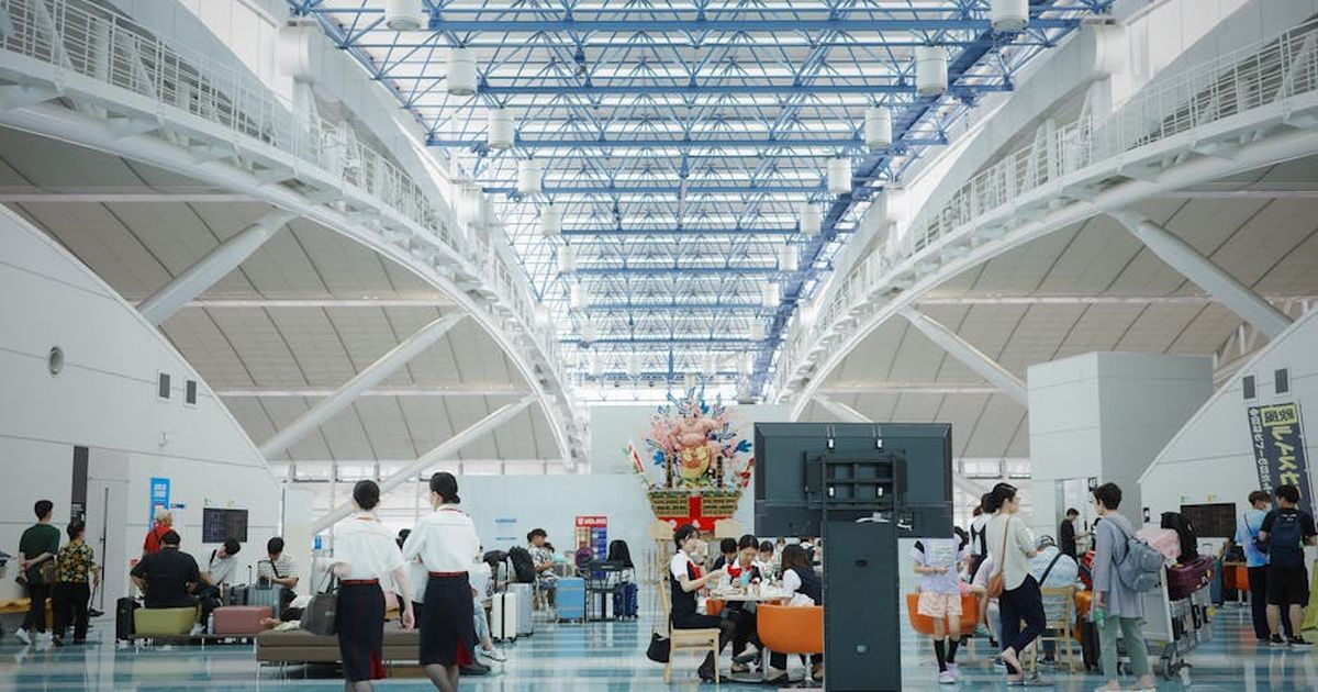 Spacious and bustling Fukuoka Airport lobby showcasing modern architecture and travelers.