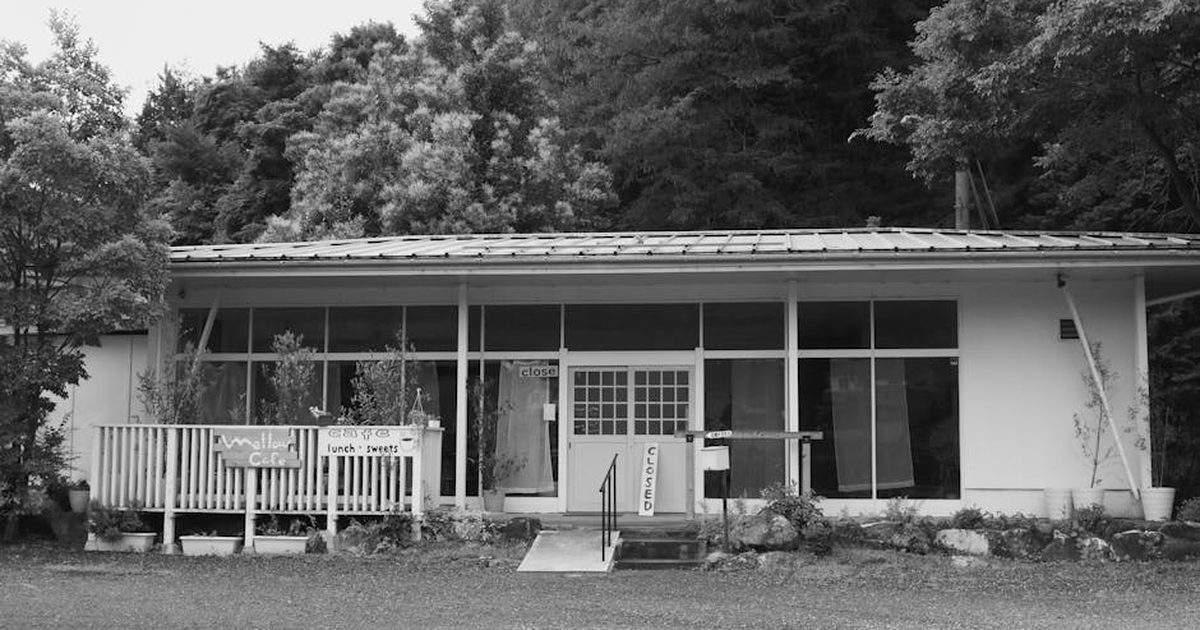 Black and white photograph of a closed cafe surrounded by lush trees in Ayabe, Kyoto, Japan.