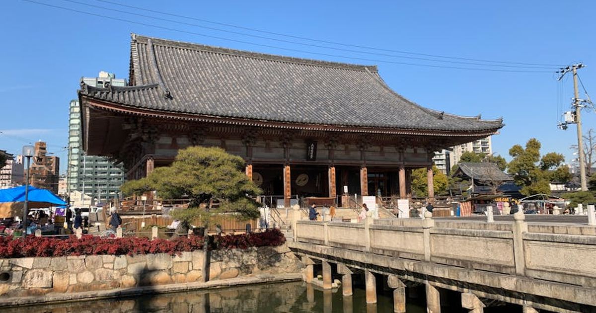 Explore the historic Shitennoji Temple in Osaka, Japan, with its traditional architecture and serene reflection on a sunny day.