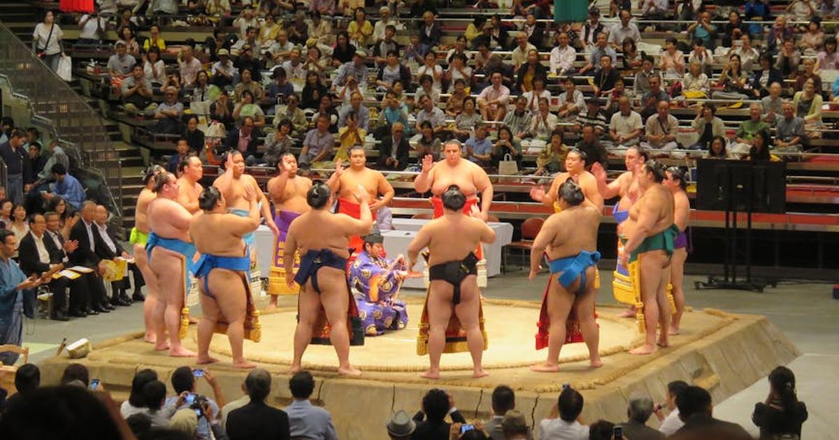 Sumo wrestlers gathered in a Tokyo arena during a traditional match.
