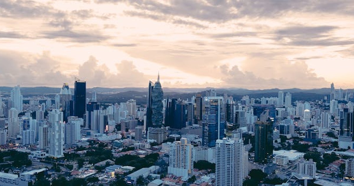 A stunning aerial view of Panama City showcasing its modern skyscrapers at sunset under an overcast sky.