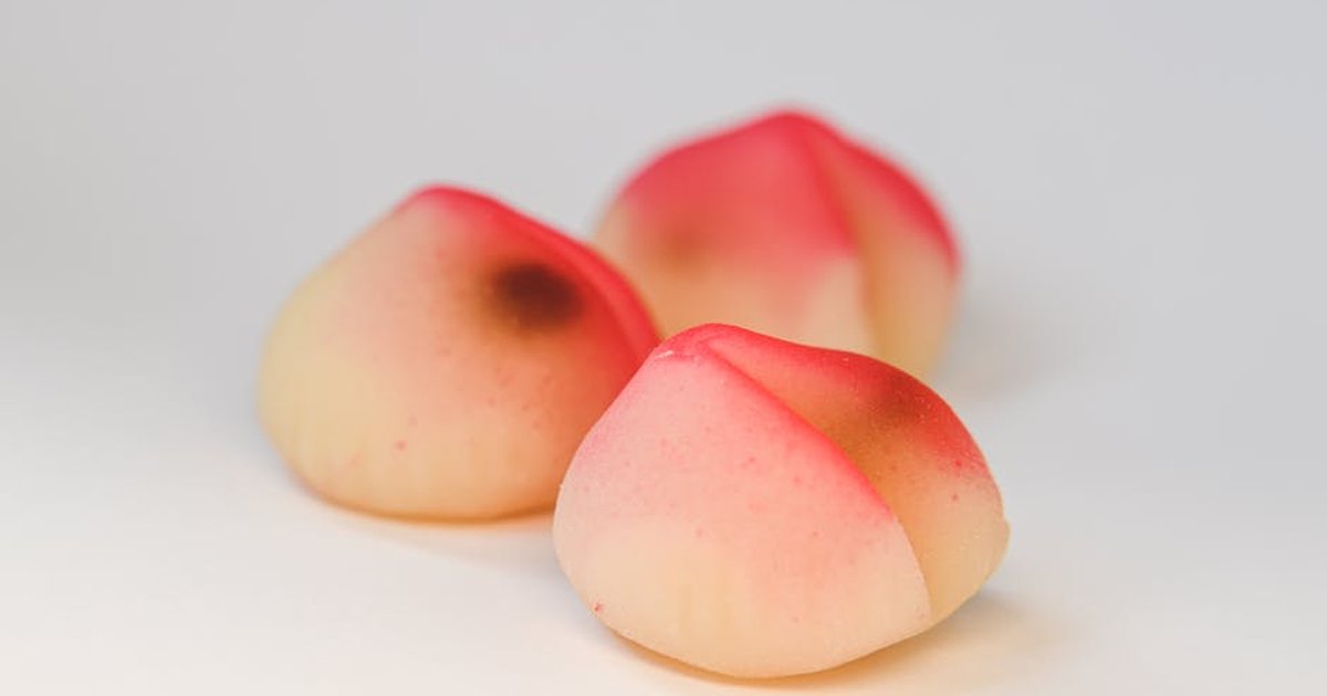 Close-up of three colorful longevity peach buns, symbolizing good fortune and health.