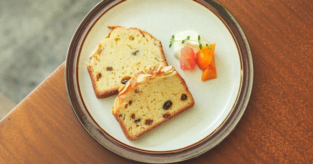 Tasty slices of plum cake served on a decorative plate with gourmet garnishes for an elegant dessert presentation.