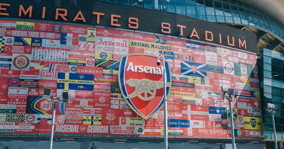 Vibrant wall art at Emirates Stadium featuring Arsenal flags and crest in London, UK.