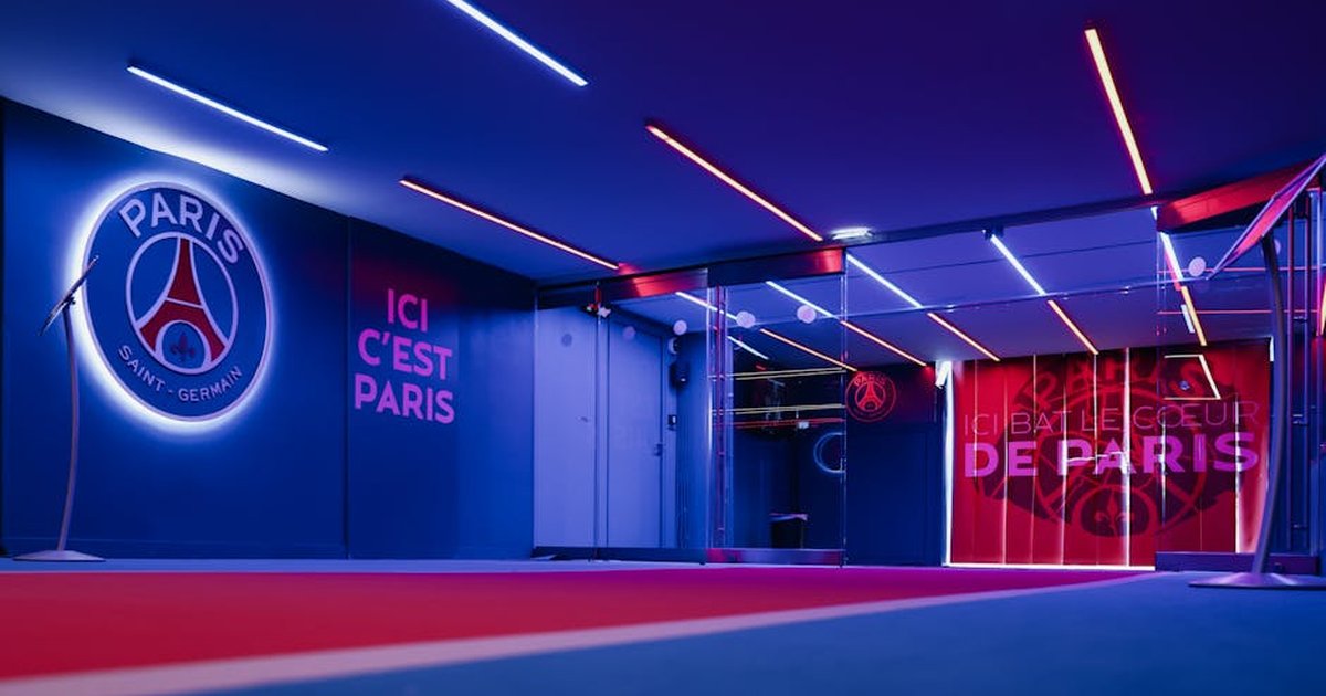Spacious PSG entrance hallway in Paris with striking neon lighting and club branding.
