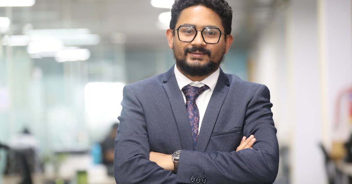 Confident man in a suit standing in a modern office, showcasing professionalism.