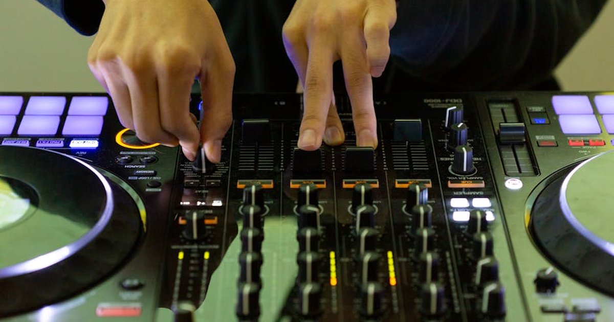 Close-up of DJ's hands mixing music on a turntable, highlighting electronic skill and nightlife.