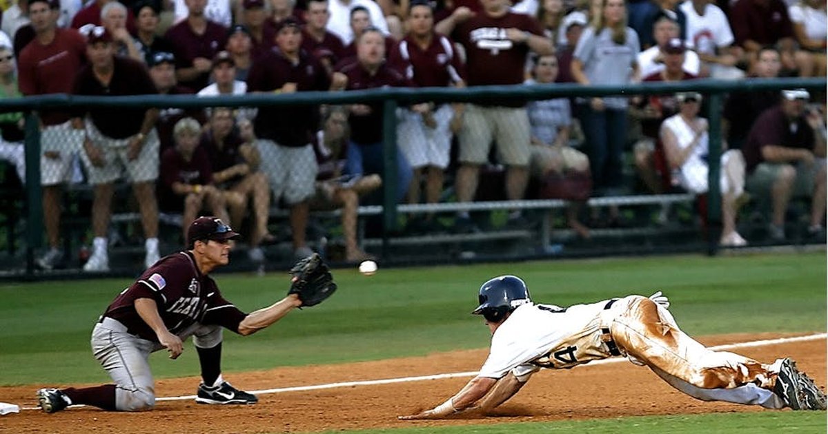 Dramatic moment as a baseball player slides home during a lively game amidst cheering crowd.