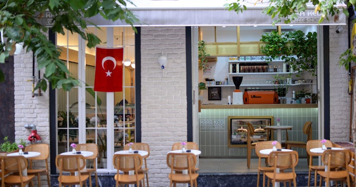 Cozy café patio with Turkish flag, elegant chairs, and welcoming atmosphere.