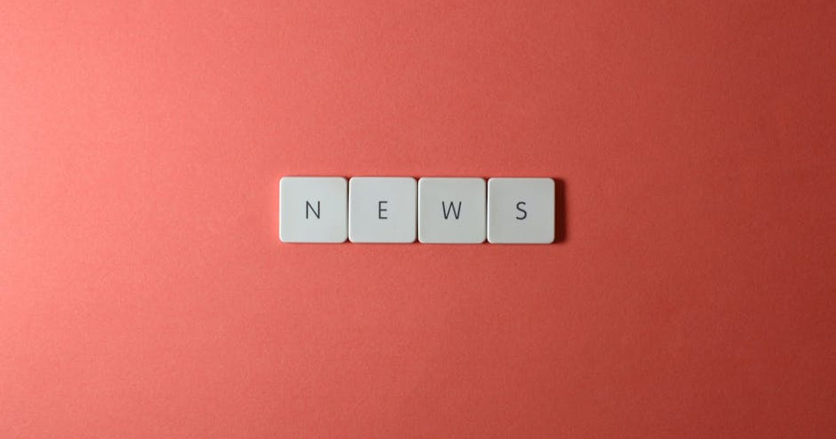 Close-up of keyboard keys spelling 'NEWS' on a red background, minimalist style.