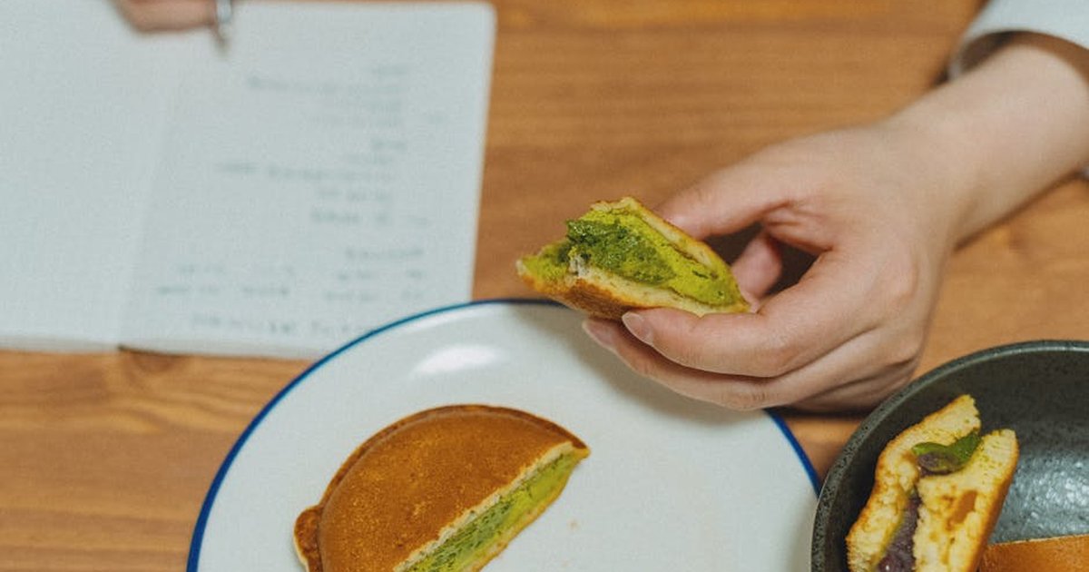 Close-up of dorayaki pancakes filled with matcha and red bean, shot indoors.
