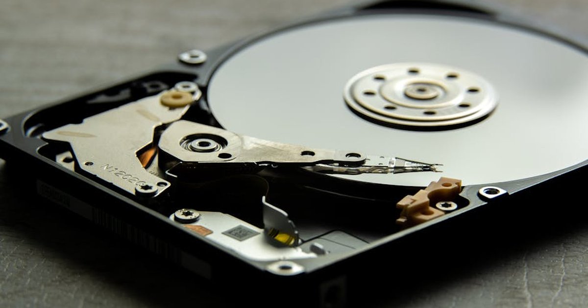 Detailed view of an open hard drive, showcasing the disk platter and actuator arm.
